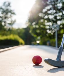 Minigolschläger und Ball auf Bahn